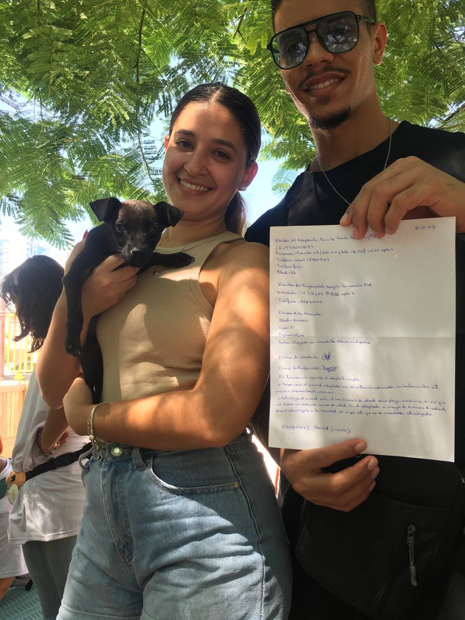 Perro feliz siendo abrazado por su nueva dueña después de ser adoptado